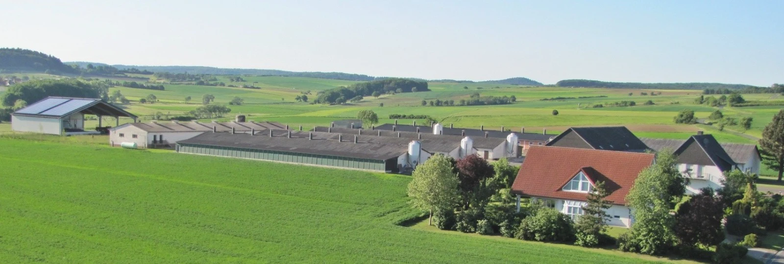 Geflügelhof Reinkemeier · Hofansicht mit Stallen, Wohnhaus und Mittelhessen-Landschaft